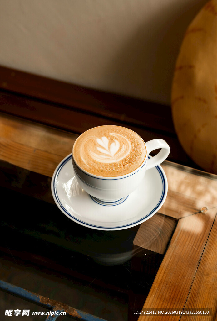 精致拉花咖啡置于木桌