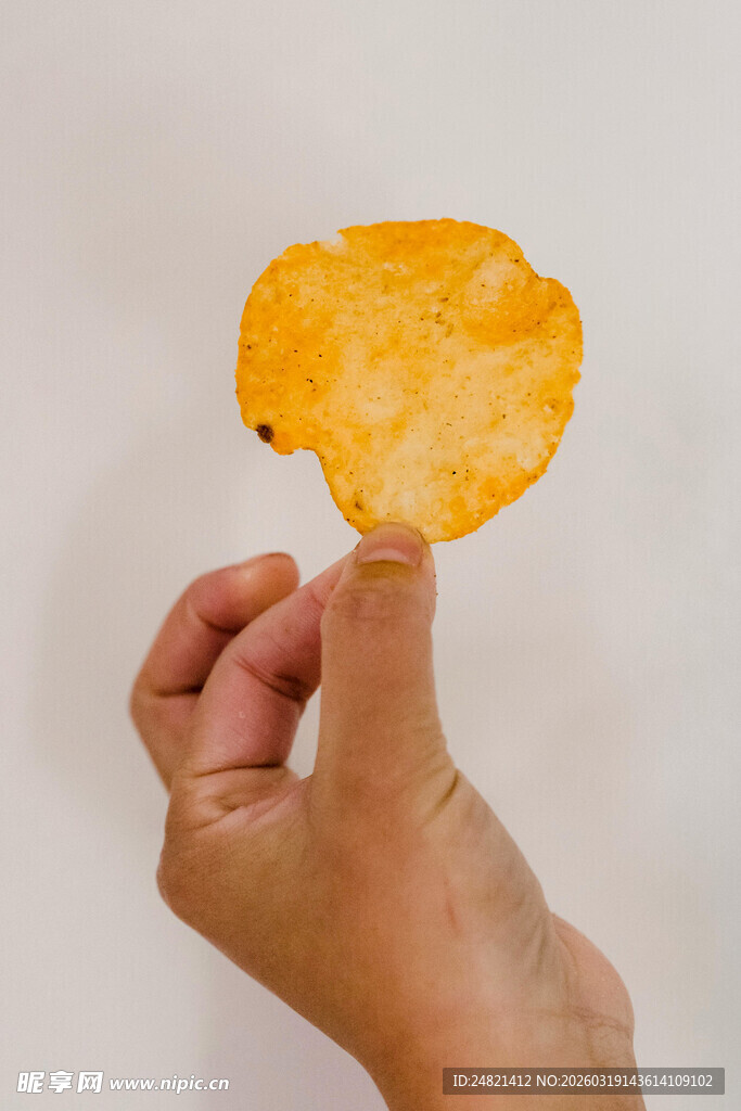 手拿一片金黄酥脆薯片