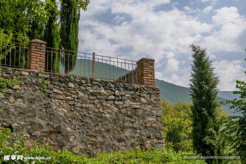 石墙旁的绿意与远山景色