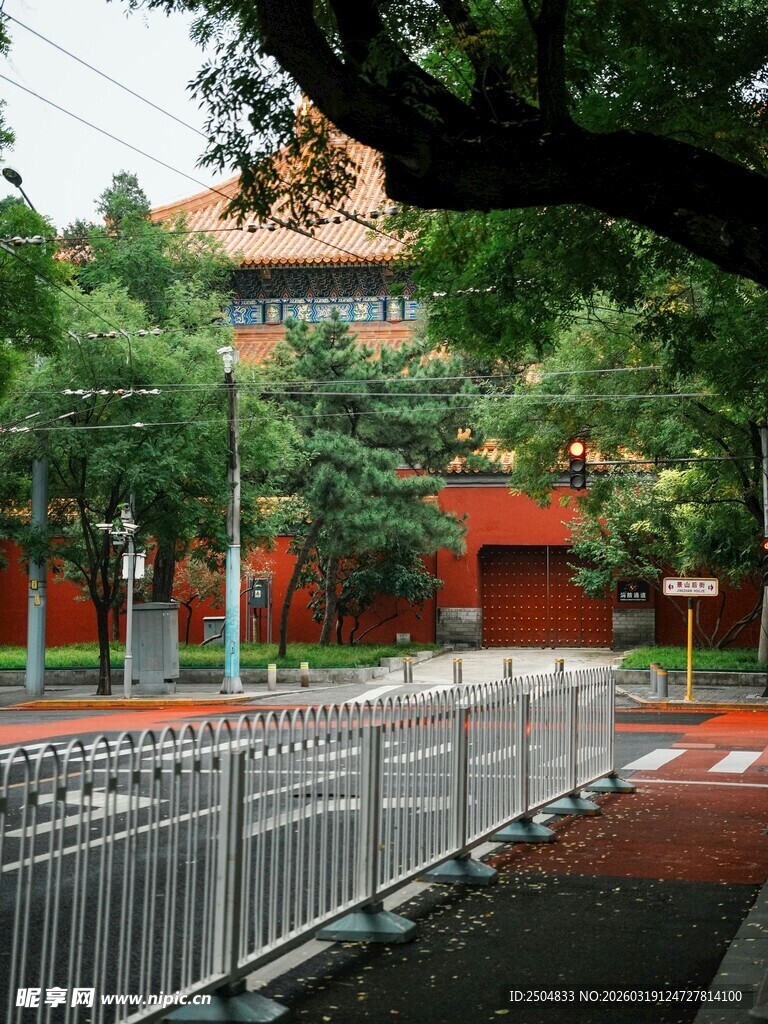 红墙绿树旁的金属护栏