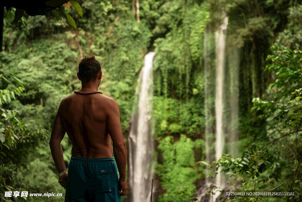 男子凝视丛林中的瀑布