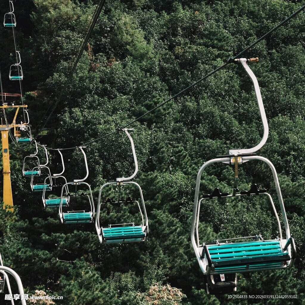 山间缆车悬挂于绿荫间