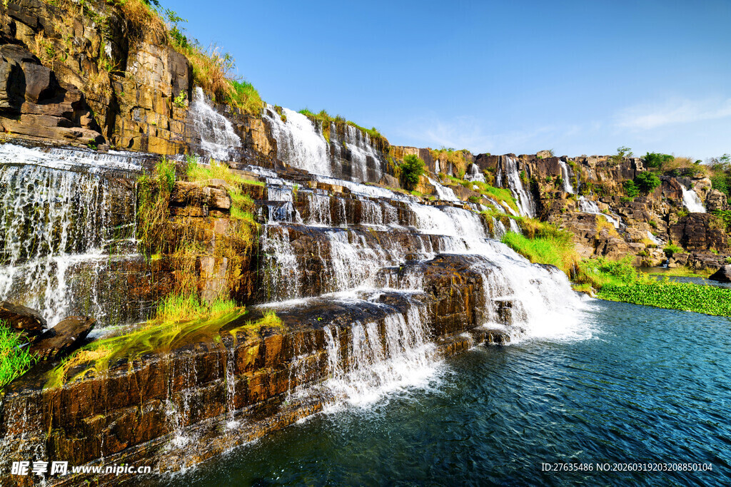 壮观瀑布下的碧绿水域