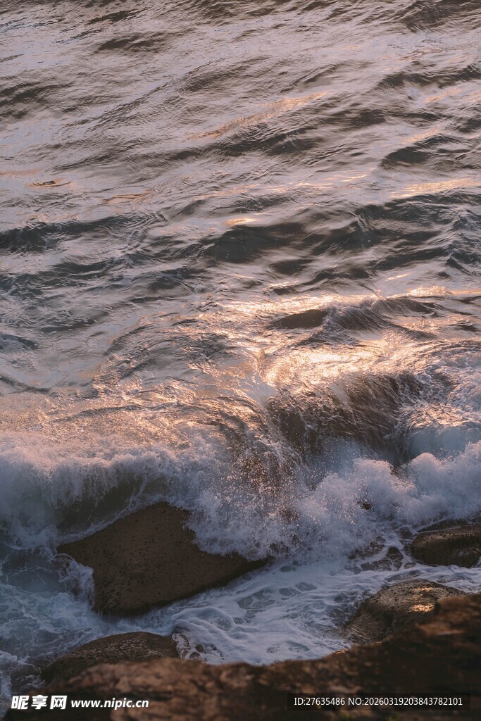 夕阳下的海浪拍打岸边