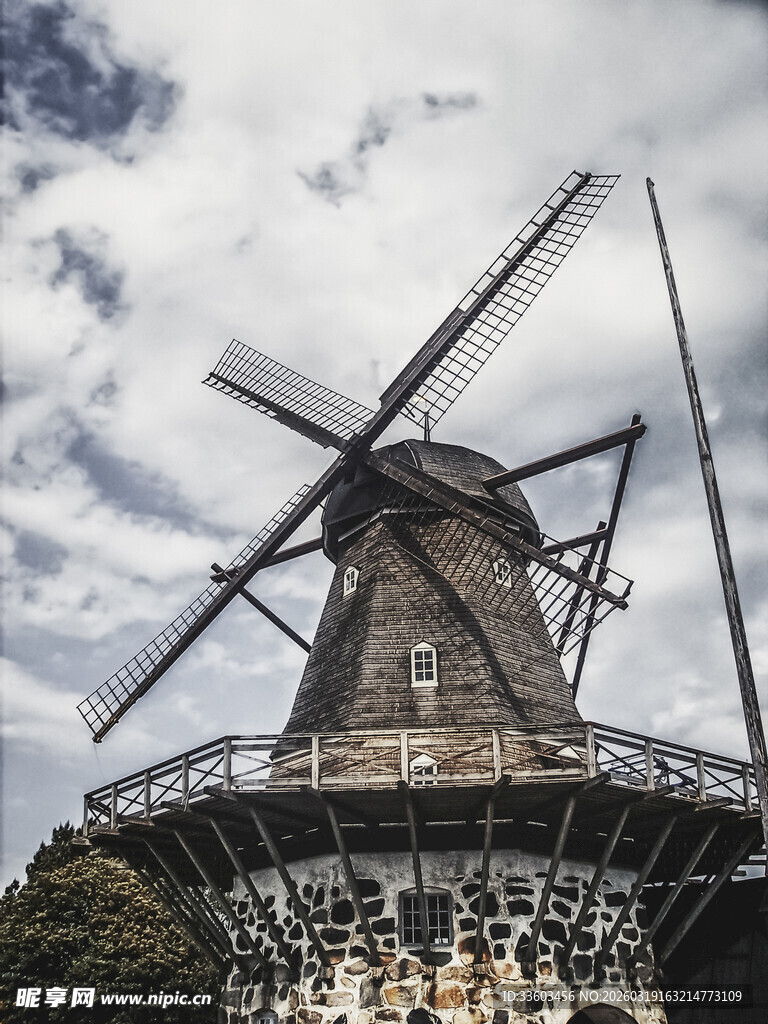 古老风车矗立蓝天白云下