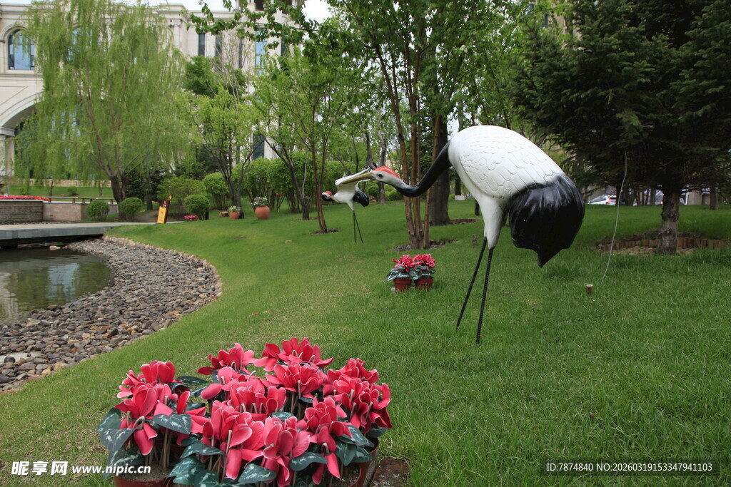 草坪上的仙鹤雕塑与花卉