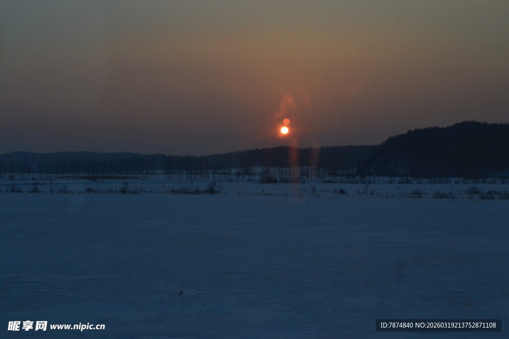 夕阳下的雪地与远处灯塔