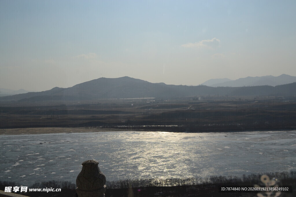 夕阳下的河畔与远山