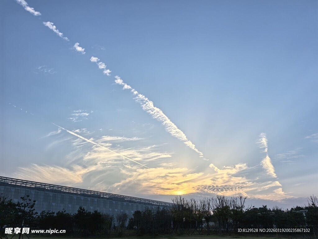 夕阳下的天空与飞机尾迹