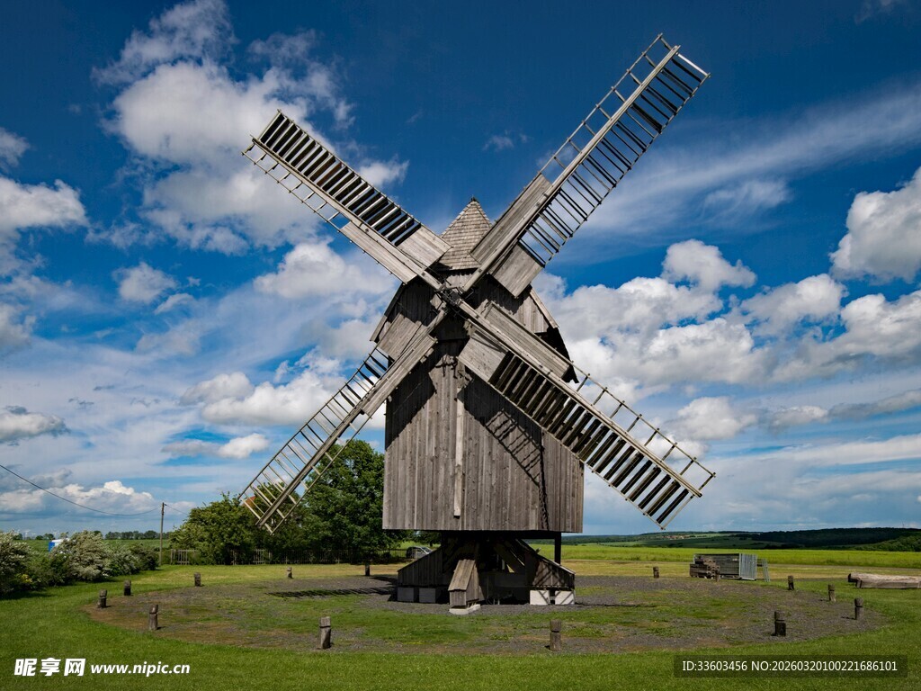 古老风车屹立于绿野蓝天
