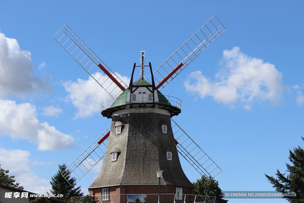 古老风车矗立蓝天白云下