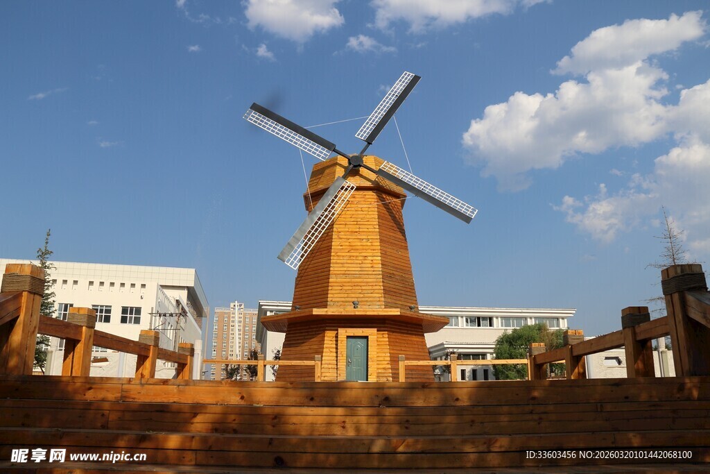 古朴风车屹立于蓝天白云下