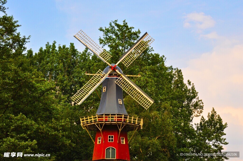 红色风车矗立绿树间