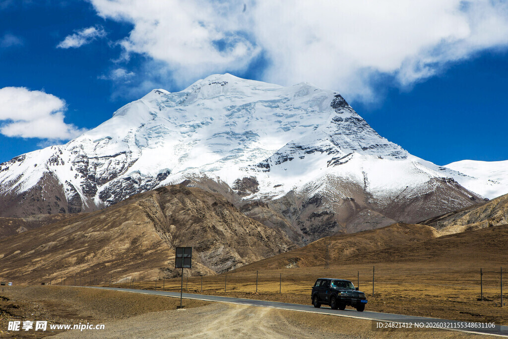 雪山下公路上行驶的汽车