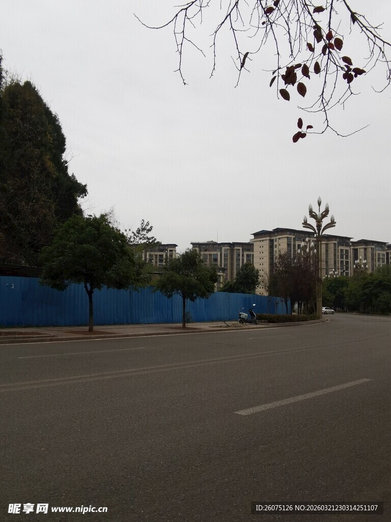 空旷道路旁的蓝围栏建筑