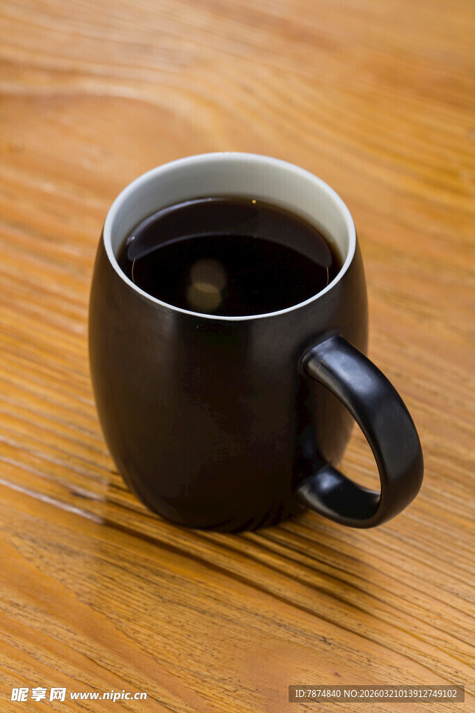木质桌上的深色咖啡杯