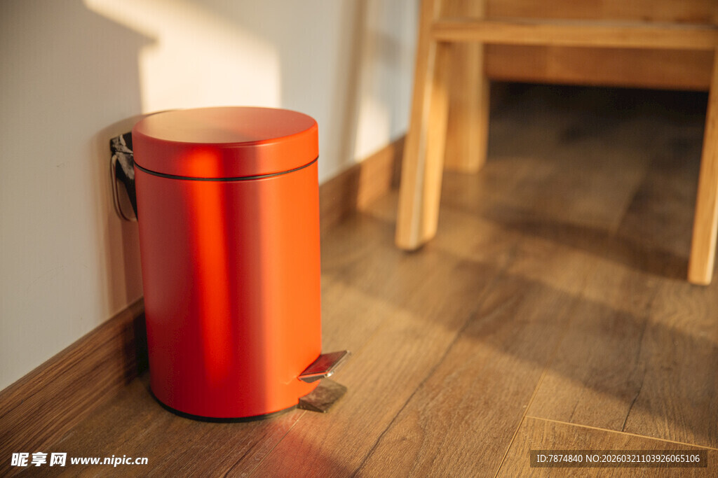 红色金属垃圾桶靠墙而立