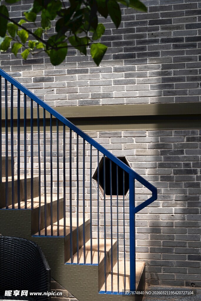 蓝色铁艺楼梯与砖墙光影