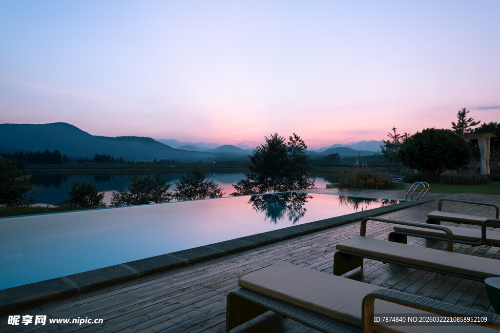 黄昏下的泳池与休闲躺椅