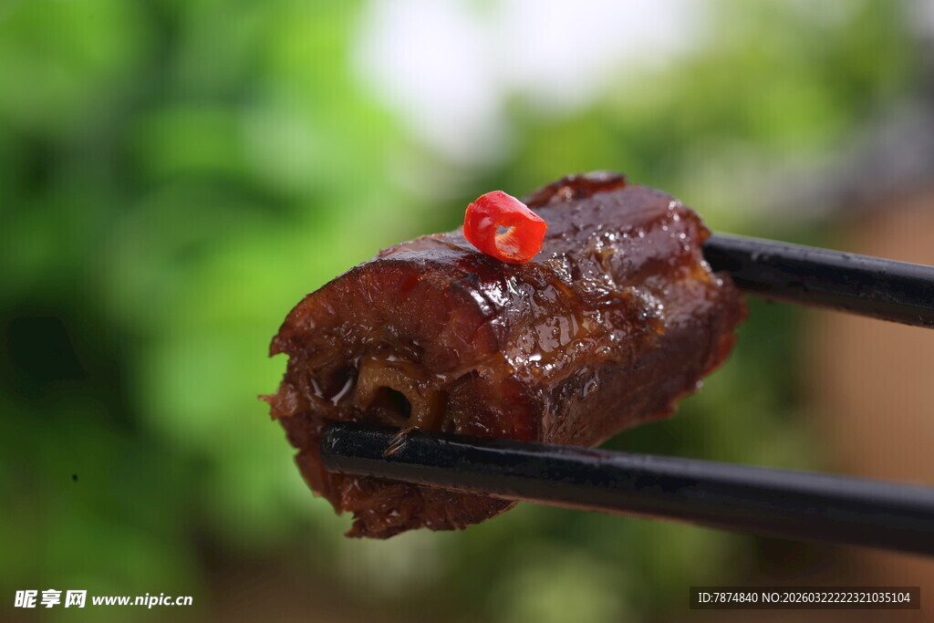 筷子夹着的美味卤鸭脖