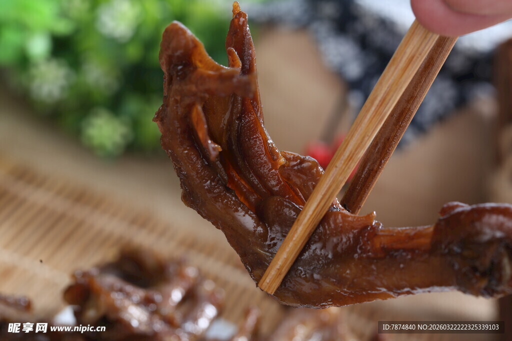 手用筷子夹特色卤味鸭爪