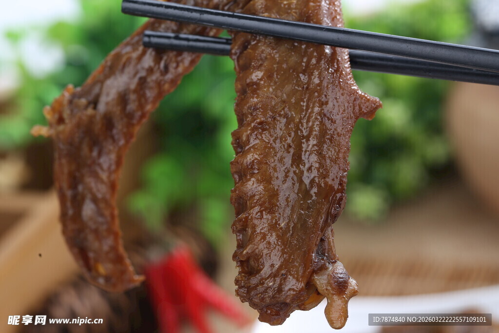 筷子夹起的美味卤鸭翅