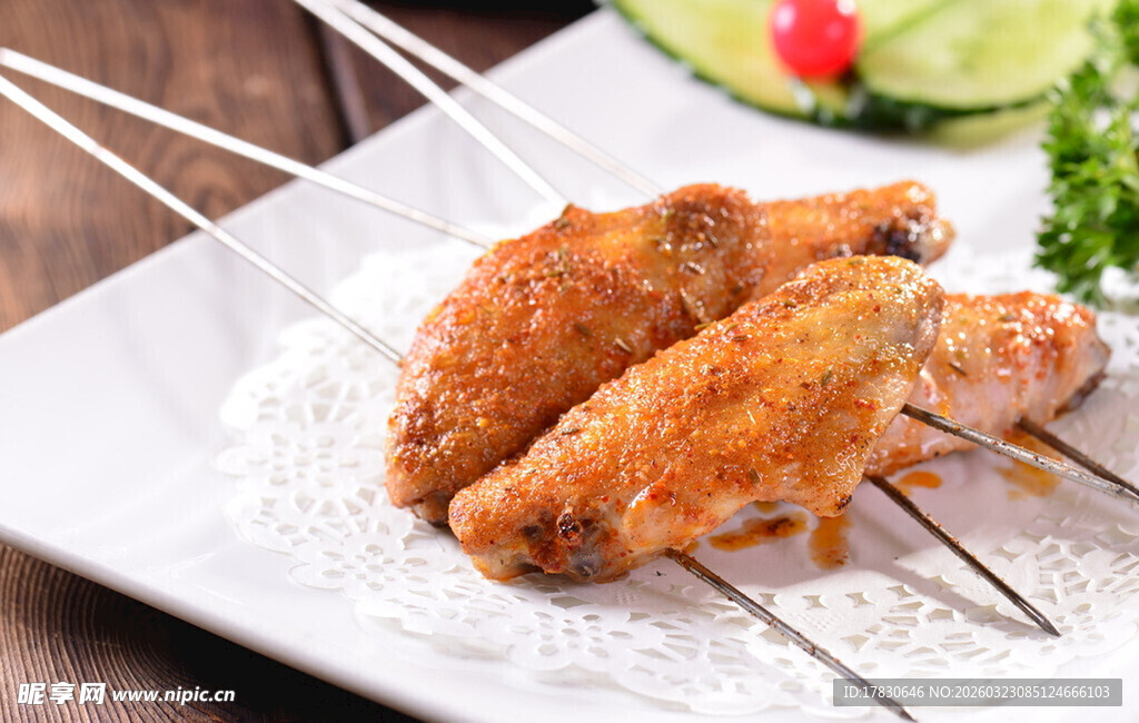 烤鸡翅串在白色盘上