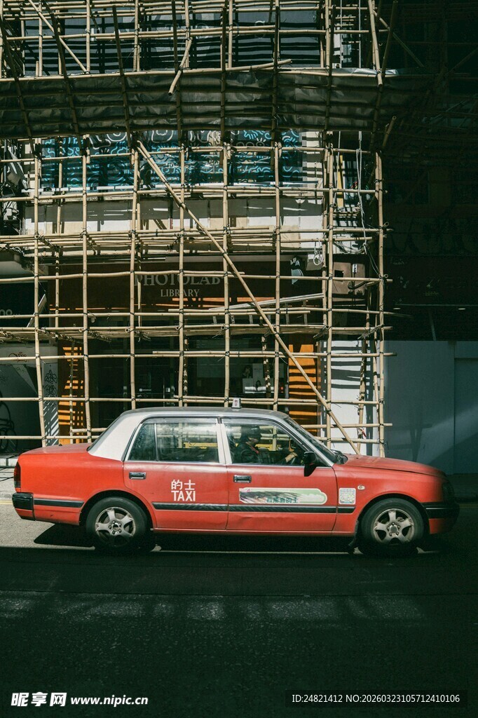 脚手架下的红色出租车
