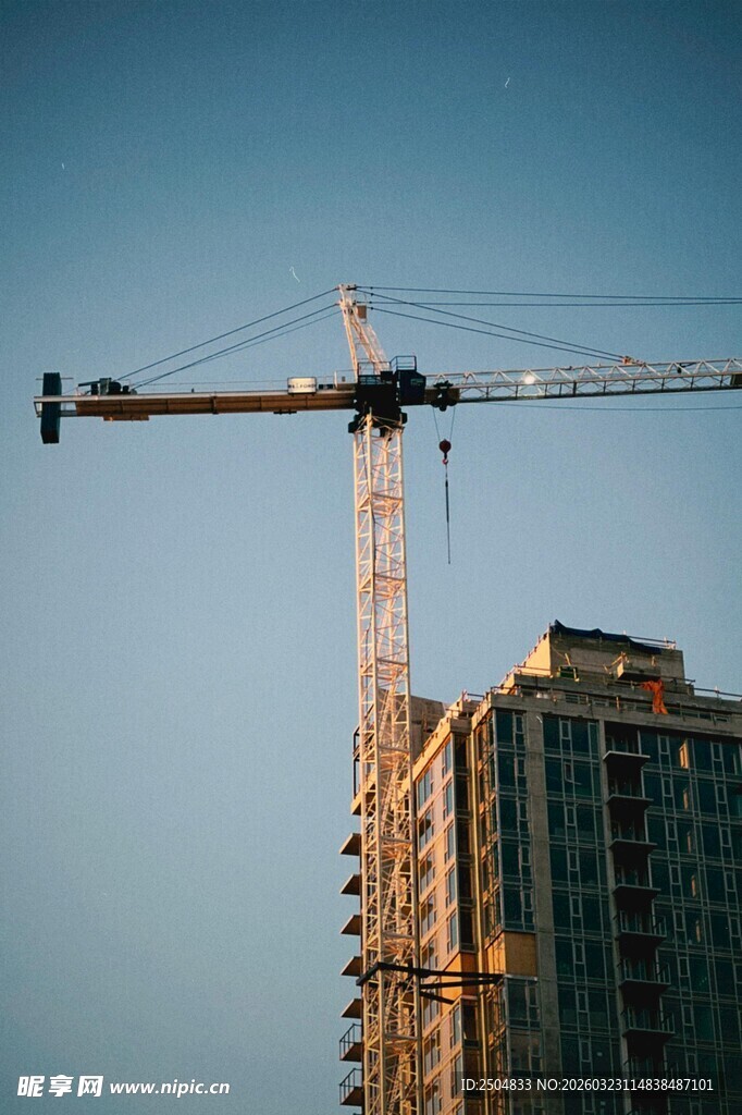 高楼旁的塔式起重机作业