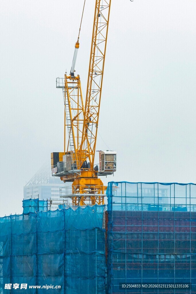 工地塔吊与蓝色建筑防护网