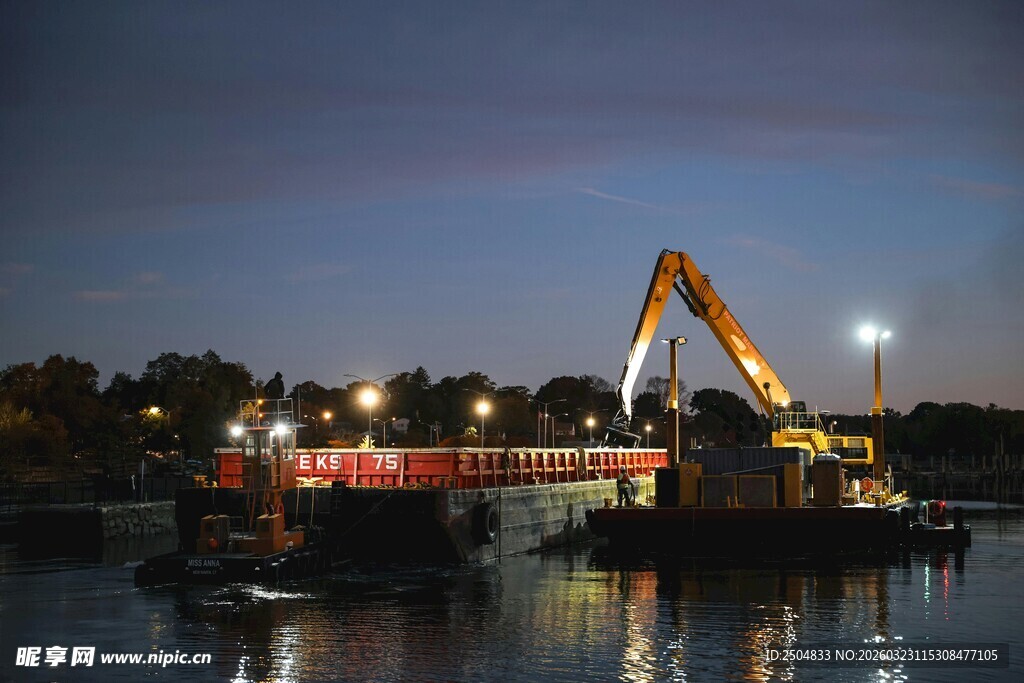 夜晚水上的挖掘机作业场景