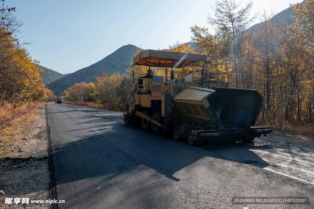 秋日公路上的施工压路机