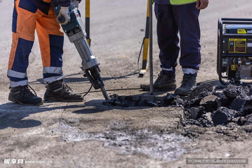工人进行路面钻孔作业
