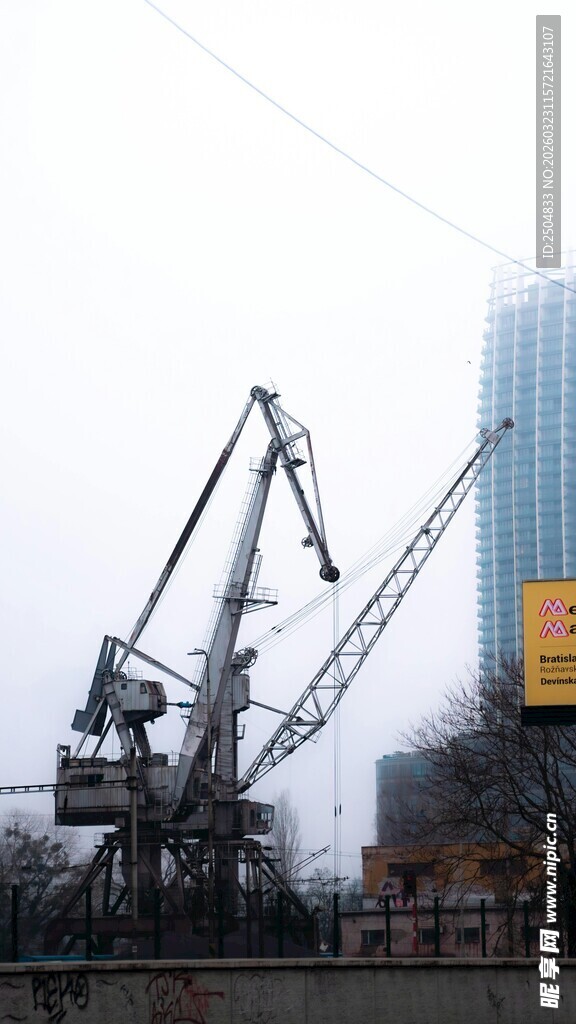 老旧起重机与现代建筑景观