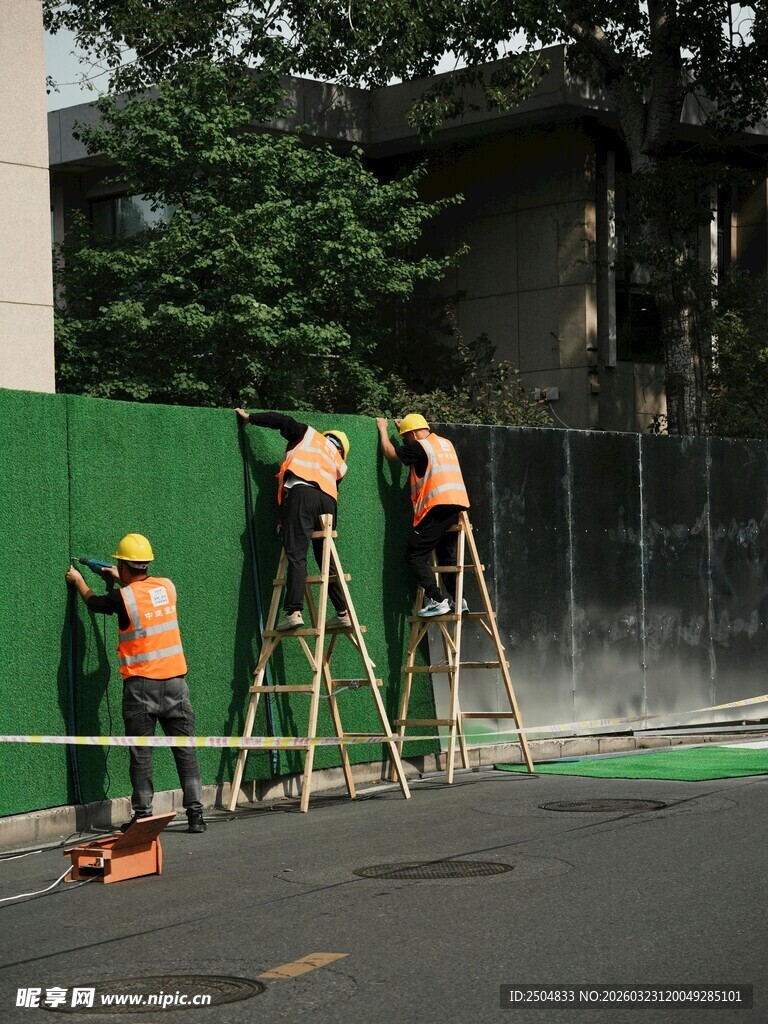 工人站梯刷漆作业场景