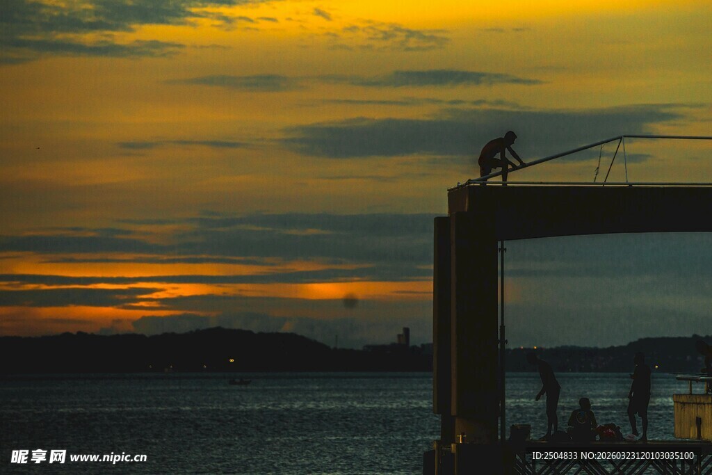 夕阳下的码头垂钓者