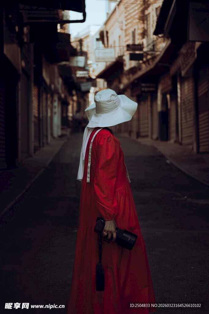 红衣人物于古朴街巷独行