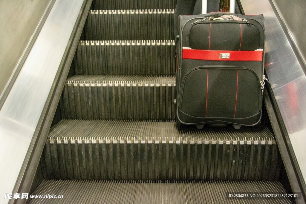 行李箱在自动扶梯上移动
