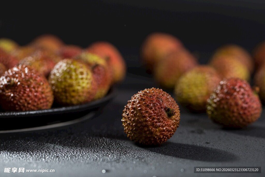 新鲜荔枝摆放在黑色盘边