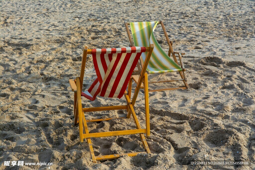沙滩上的两把条纹折叠椅