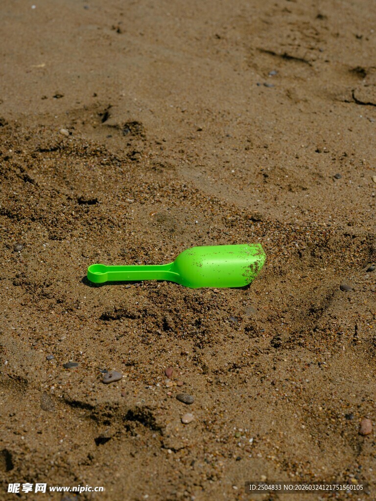 沙滩上的绿色小铲子