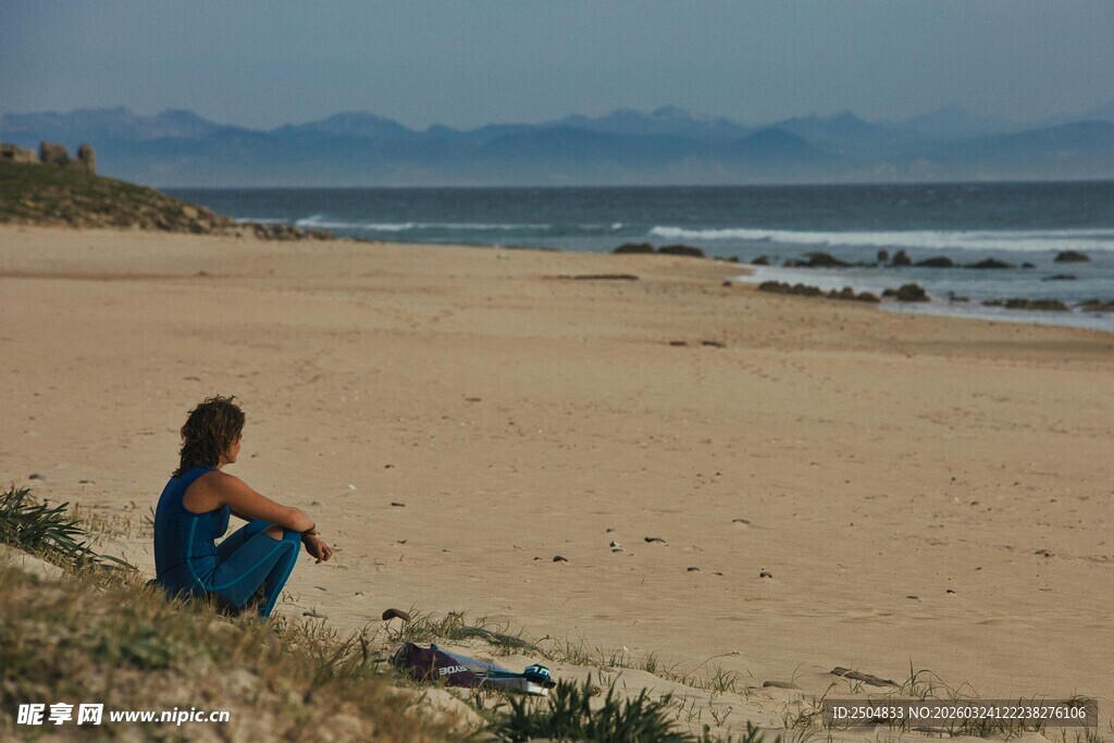 女子独坐沙滩望海