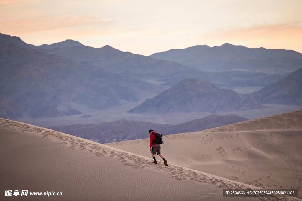 徒步者穿行于 漠山丘间