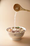 木勺浇汁于多彩食材碗中