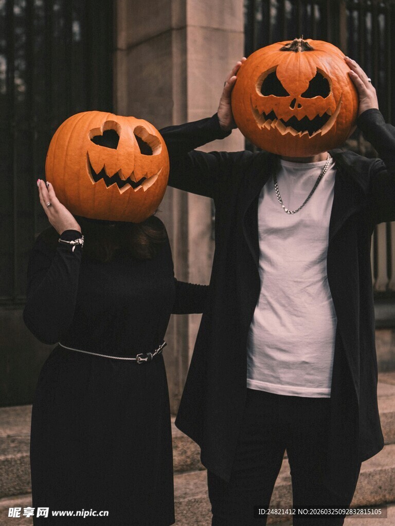 两人手持南瓜头搞怪装扮