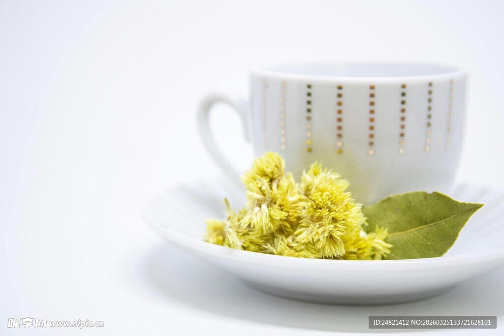 白杯旁的椴花与绿叶