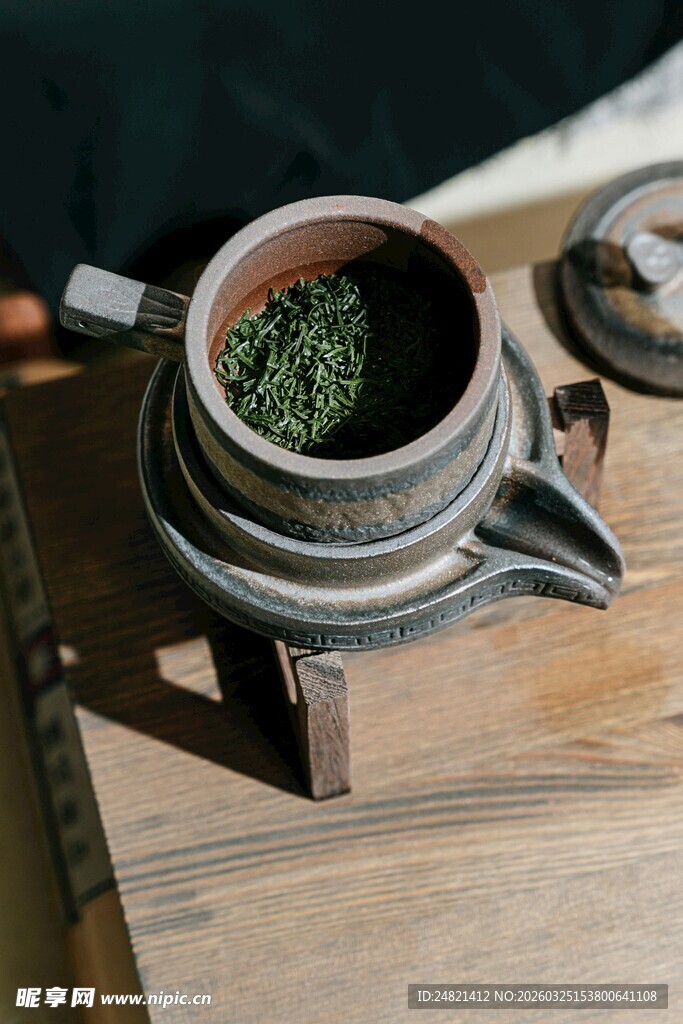 古朴茶具盛着嫩绿茶叶