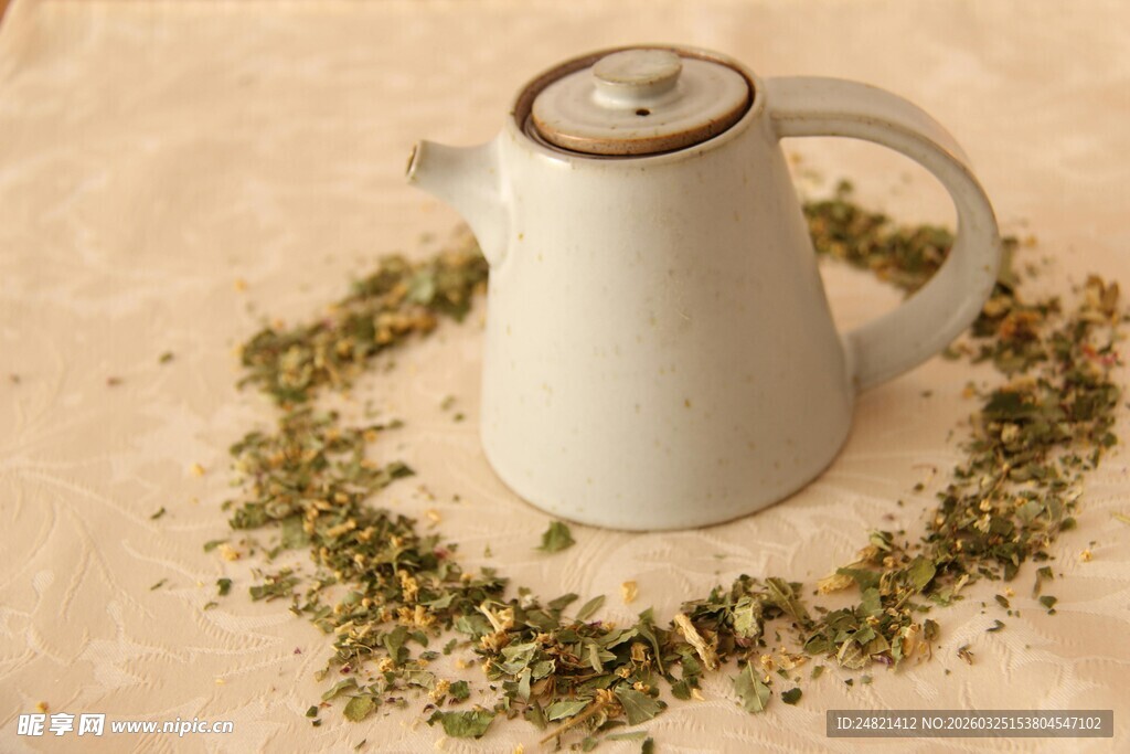 白色茶壶与散落的干茶叶