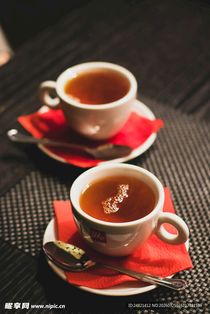 两杯热茶置于红垫上