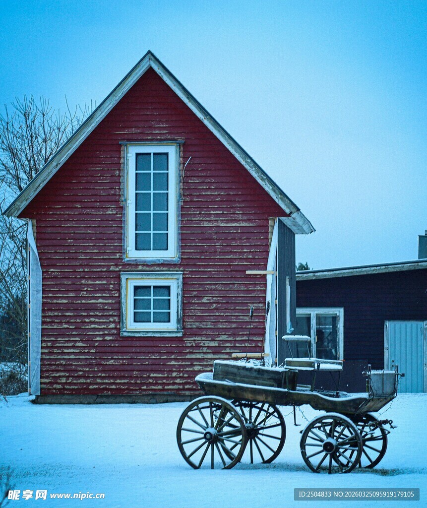 雪中小屋旁的复古马车
